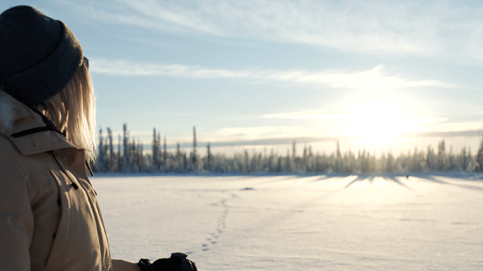 person looking out on snow cover lake